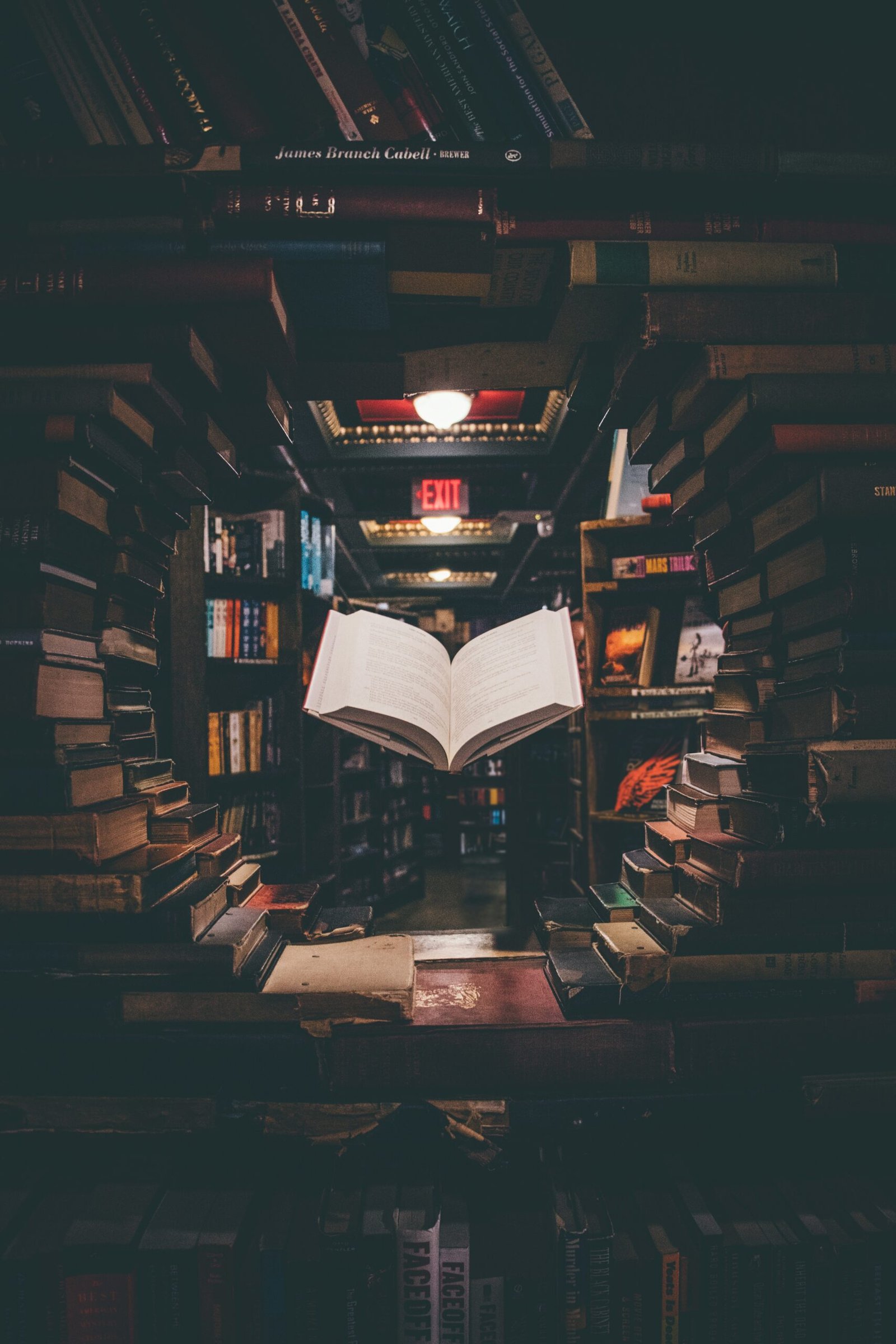 view of floating open book from stacked books in library