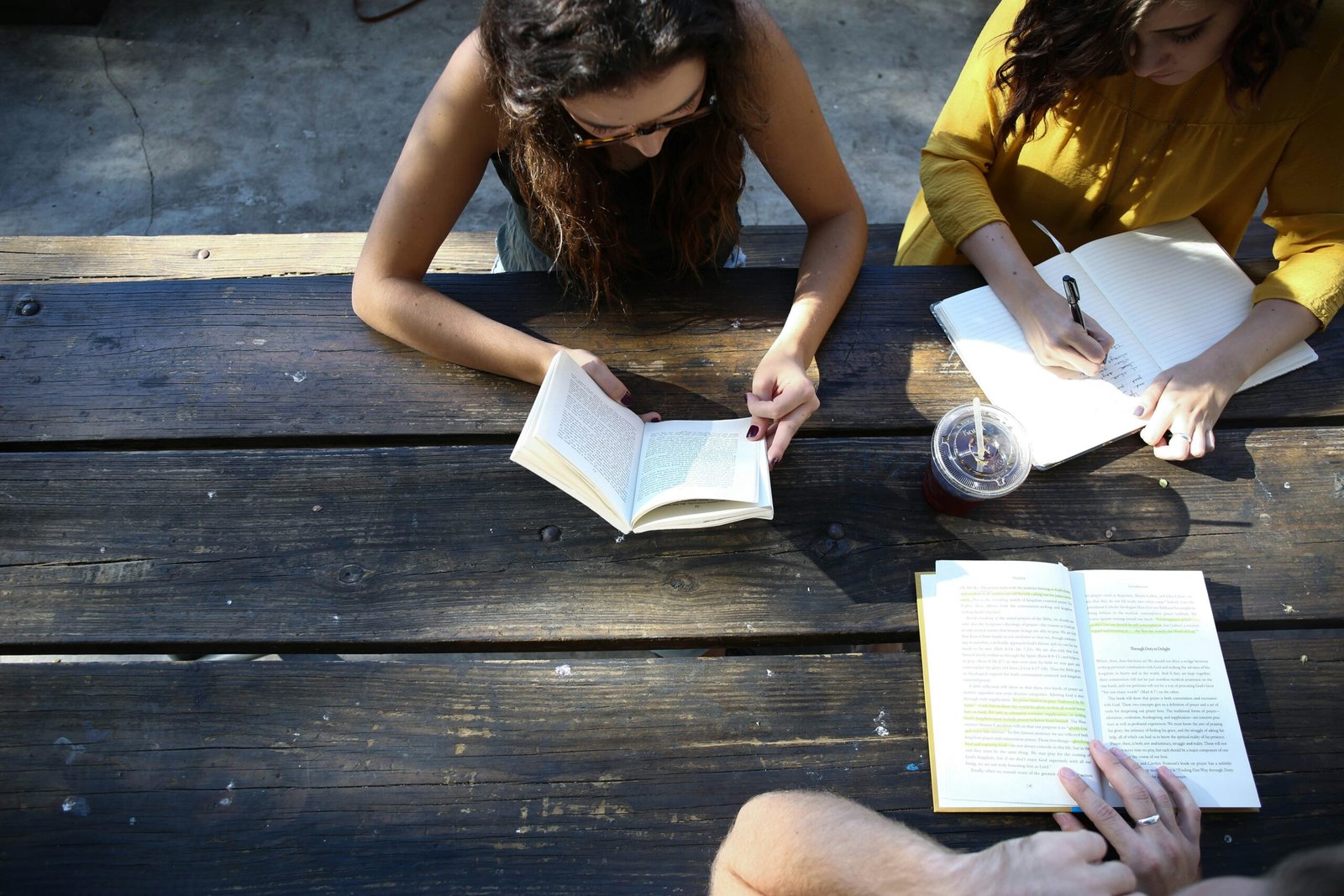 woman reading book while sitting on chair